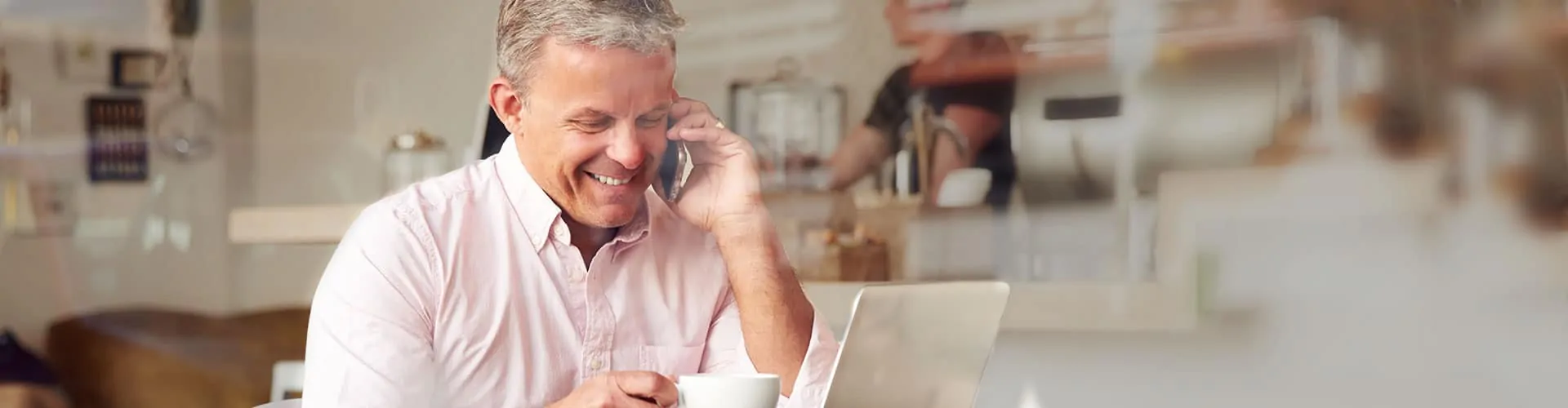 man talking on phone while looking at computer